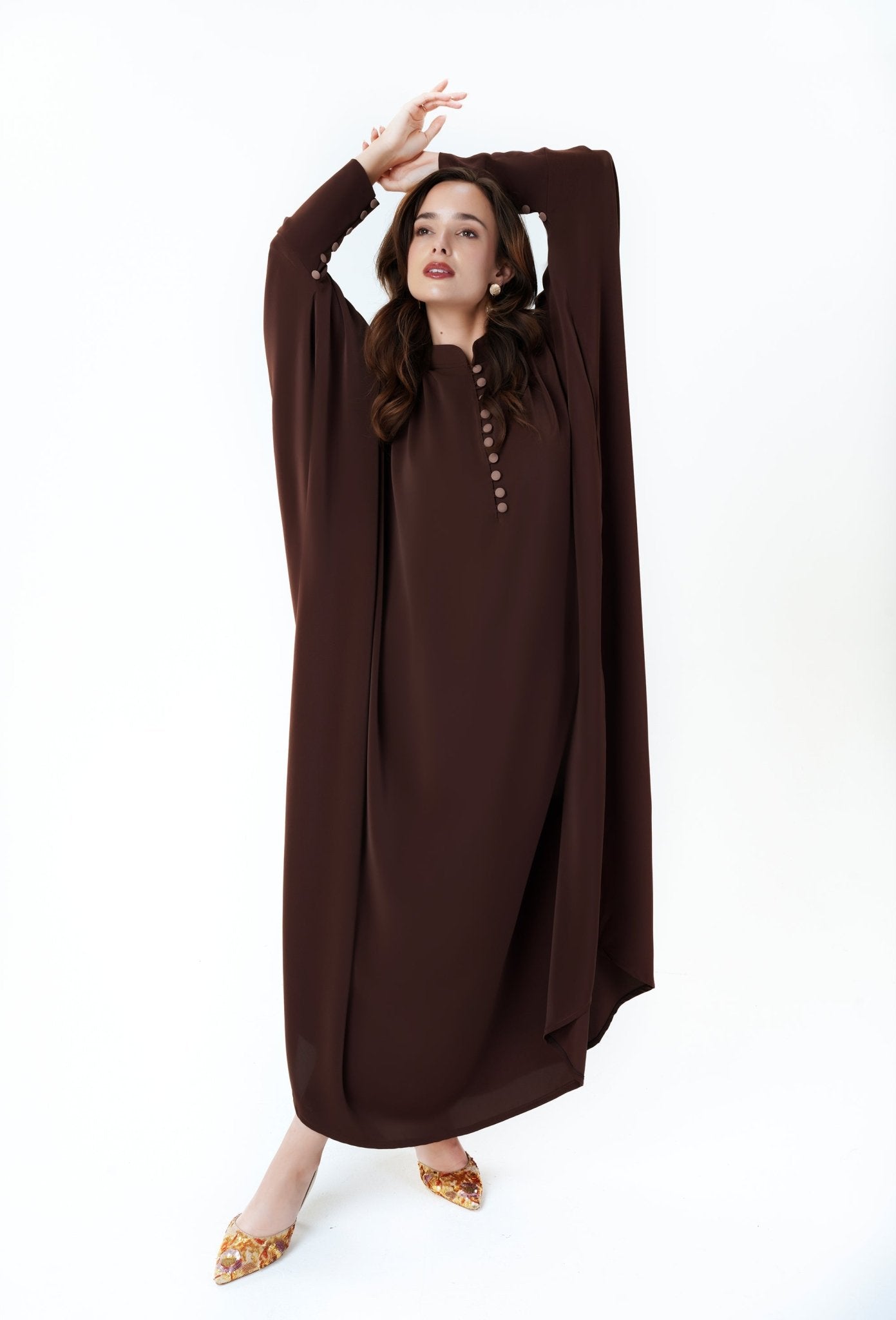 velvet road abaya- Woman wearing beautiful brown batwing abaya with contrast buttons. Elegant fashion by MODMOD UK. Includes Hijab