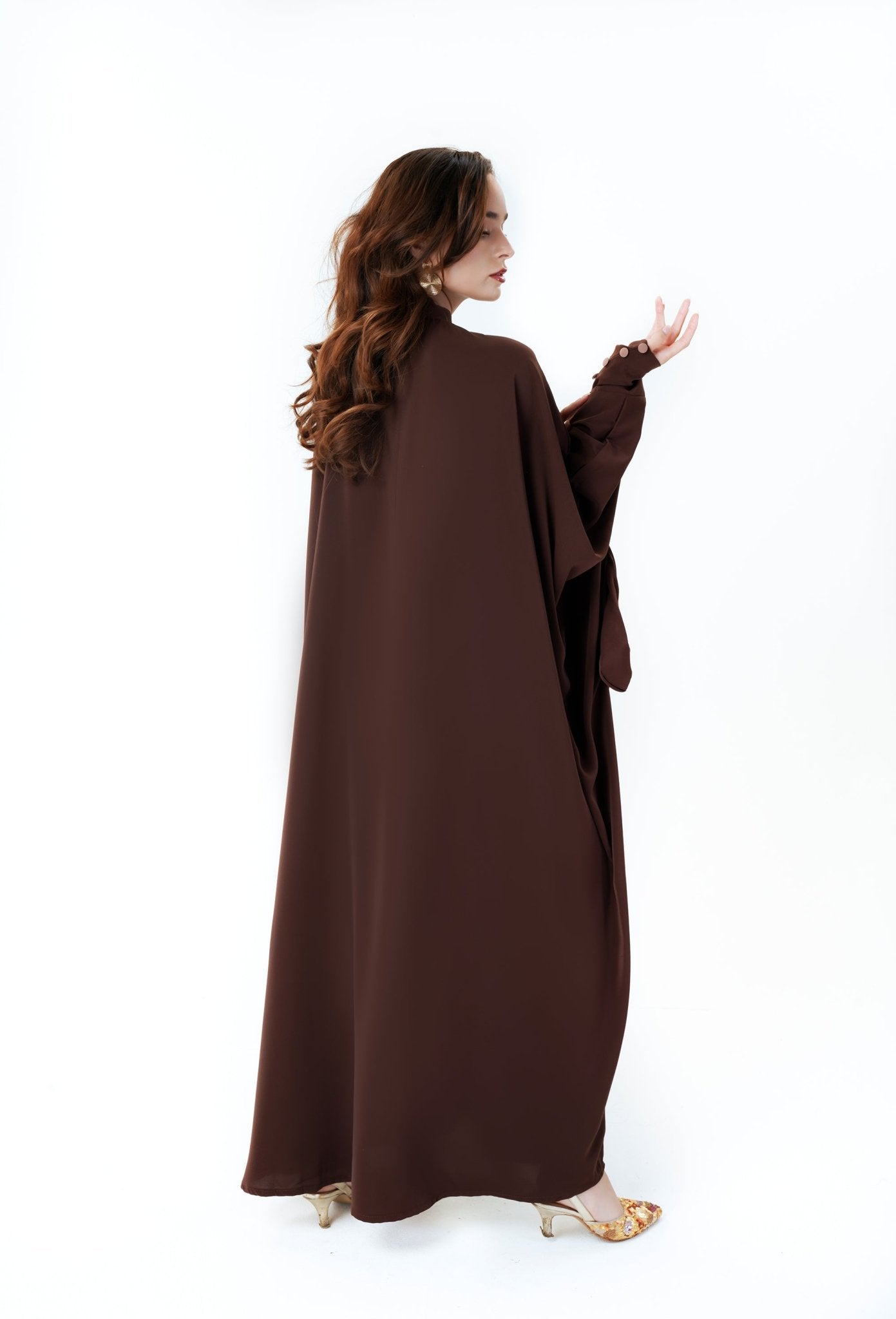 velvet road abaya- Woman wearing beautiful brown batwing abaya with contrast buttons. Elegant fashion by MODMOD UK. Includes Hijab